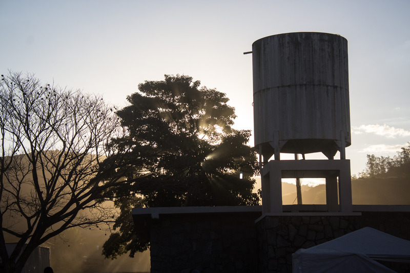 Large concrete garden water tank installed at an elevated height in a backyard garden near trees and plants